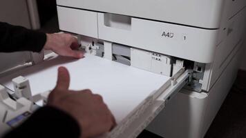 Office worker takes out a stack of paper A3 from the printer tray video