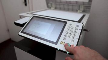 An office worker scans a sheet of A3 paper on a scanner video