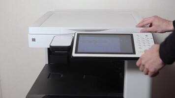 An office worker scans a sheet of A3 paper on a scanner video
