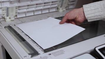 An office worker scans a sheet of A4 paper on a scanner video
