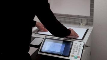 An office worker scans a sheet of A3 paper on a scanner video