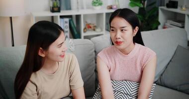 Handheld high angle view shot, Asian female couple share good feelings for each other and hold hands with their pinky fingers, indicating a good relationship or sincere promise, Happy times at home video