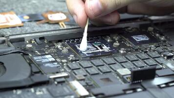 Service center repairman is removing the old thermal paste from the CPU or gpu to apply a new one video