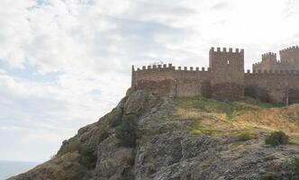 Old Genoese fortress in the city of Sudak in summer. Ancient architecture of Crimea. photo
