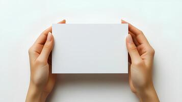 hands holding blank paper isolated on white background with shadow. Human hands gently holding a clean, white sheet of paper, perfect for mockups, presentations, and creative designs photo