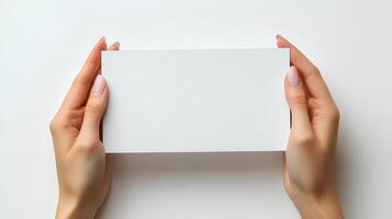 hands holding blank paper isolated on white background with shadow. Human hands gently holding a clean, white sheet of paper, perfect for mockups, presentations, and creative designs photo