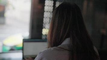 mulher trabalhando em computador portátil dentro cafeteria e bate-papo programa, inteligente amigo faz trabalhos mais fácil video