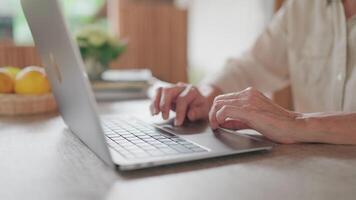 Close-up - Hands of middle-aged woman typing on laptop at desk, thinking or expressing concern, looking at device screen, studying received email, contemplating work, working online. video