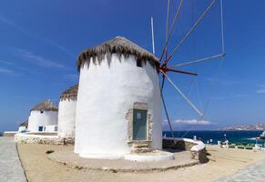 Traditional Greek windmills on Mykonos island under cloudy sky. Aerial view of iconic Mykonos windmills in Cyclades, Greece. photo