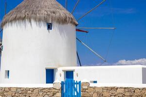 Traditional Greek windmills on Mykonos island under cloudy sky. Aerial view of iconic Mykonos windmills in Cyclades, Greece. photo