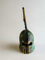 Bell in the form of an ancient Greek helmet made of bronze on a white background. photo