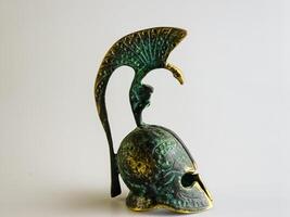 Bell in the form of an ancient Greek helmet made of bronze on a white background. photo