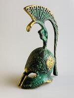 Bell in the form of an ancient Greek helmet made of bronze on a white background. photo