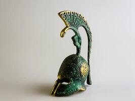 Bell in the form of an ancient Greek helmet made of bronze on a white background. photo