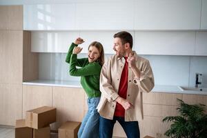 Happy couple dancing back to back, celebrating housewarming, moving in new home, ready to unpacking photo