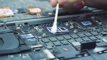Technician in hardware service cleans the CPU or gpu from the old thermal paste to apply a new one video