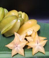 Multicolored overlapping star fruit background image on black background photo