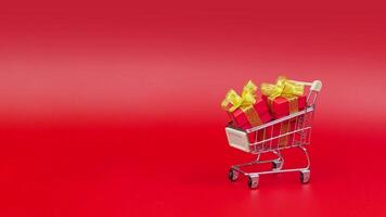 Shopping cart goes and gifts box appear in it. Concept of shopping and gifts for New Year and Christmas, Birthday, Sales and February 14. Copy space, stop motion animation 4k video