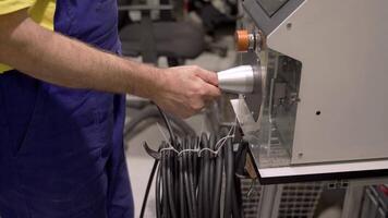 A man in blue overalls is using a machine video
