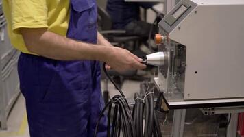 A man in blue overalls is using a machine video