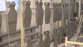 A large number of metal chairs are lined up in a factory video
