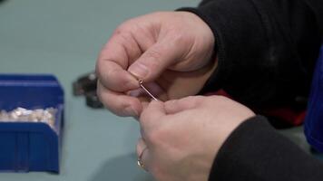 A person is using a pair of scissors to cut a piece of wire video