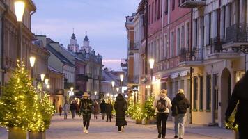Kaunas, Lithuania - 17th november, 2024 - lithuanian pedestrians walk in famous central streets of Kaunas. City in south-central Lithuania. Beautiful old traditional line of houses. Christmas holidays video