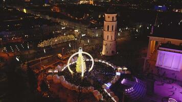Vilnius, Lithuania - 30th november, 2024 - aerial zoom cathedral square and Xmas market visitors sightseeing beautiful Xmas tree in city Vilnius - the european capital of Christmas 2025 video