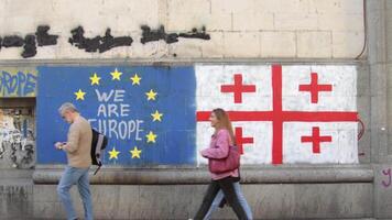 Tbilisi, Georgia - 16th may, 2024- Eu and Georgian flag on wall, statement we are EUROPE.No russian law movement. Integration process to EU concept.Sports and supportive fans concept. Voters go vote video