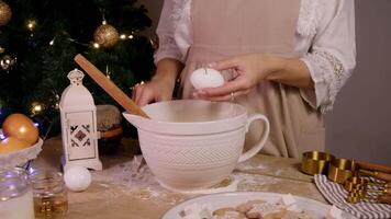 Baker breaks an egg and adds it to bowl for making a variety of Christmas pastries, including cakes, pies, and ginger cookies. video