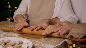 A loving couple, working together, spread the dough on a flour-covered table, preparing to bake delicious ginger cookies. video