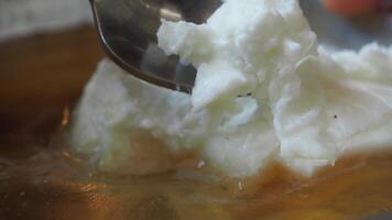 butter cream and honey in a bowl on table . video