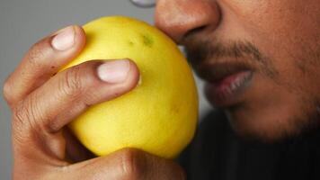 Close-Up of Person Holding and Smelling a Fresh Yellow lemon in Hand video