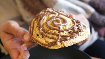 A Delightful Oversized Cookie with Rich Chocolate Drizzle in Hand video