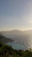 The sun is setting over the ocean and mountains video