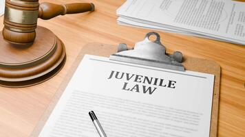 Wooden Lawyer Desk with Highlighted Word 'JUVENILE LAW' on Clipboards Documents on Table. Judge's Wooden Gavel Knocking and Court Making Decision on 'JUVENILE LAW' in Courtroom. video