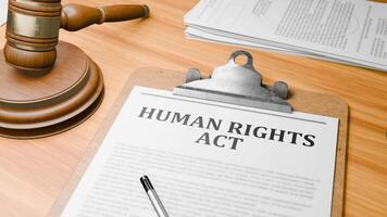 Wooden Lawyer Desk with Highlighted Word 'HUMAN RIGHTS ACT' on Clipboards Documents on Table. Judge's Wooden Gavel Knocking and Court Making Decision on 'HUMAN RIGHTS ACT' in Courtroom. video