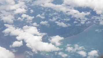aerial view over cloudscape from airplane flying with thick fog and cloud above the beautiful natural sea beach bay in rainy day video