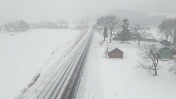 An aerial view of a train traveling through a snowy field video