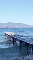 A pier in the water with a ship in the background video