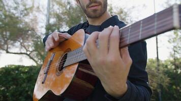 Playing Guitar And Tapping With Hand On Sound Box In A Park video