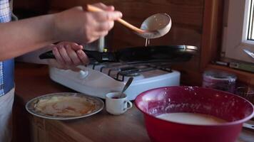 Fry thin pancakes closeup. Pour dough with ladle into frying pan and spread over surface. Cooking step, necessary ingredients and utensils, recipe. Home baking is delicious and nutritious food. video