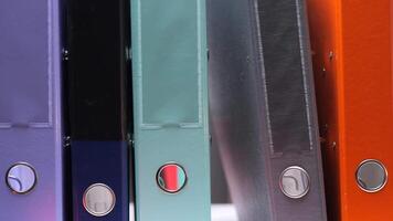 one folder is pulled out from a row of colored folders with documents video