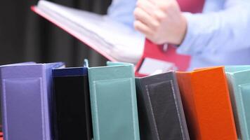 Office worker reading documents with colorful ring binders in the foreground video