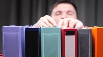 Office worker searching files in colorful binders archive video