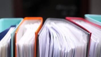 close-up Colorful ring binders standing in a row, containing many documents video