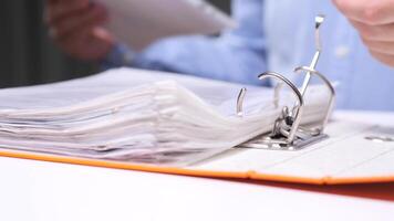 Office worker inserting documents into folder binder video