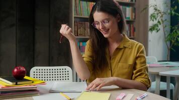 Caucasian woman girl write task homework test exam successful good grade result yes gesture female high school student writing copybook study learn at desk university class college education smiling video
