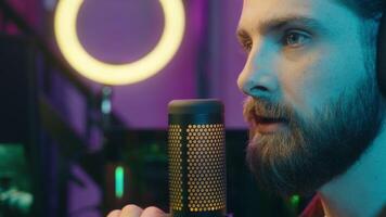 Cheerful glad Caucasian radio streamer gamer man streaming blog discussing microphone guy influencer smile talk blogger male playing digital game vlog online app computer at home cyber sport e-sport video