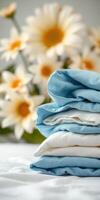 Stacked bed linens with delicate flowers in the background creating a serene morning ambiance photo